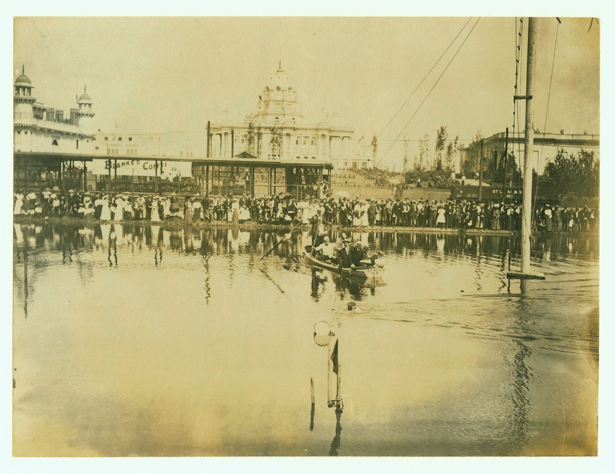 Bitiş çizgisini geçen bir yüzücünün yatay fotoğrafı. Teknedeki adamlar, kıyıdaki insan kalabalığının yanı sıra izliyor by Unknown